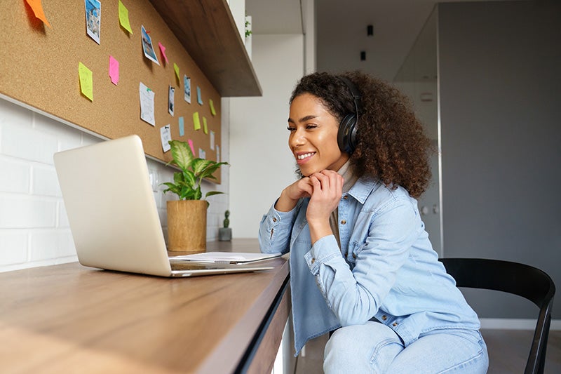 A woman on a laptop with headphones on